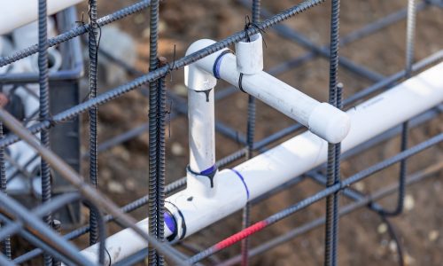 Newly Installed PVC Plumbing Pipes and Steel Rebar Configuration At Construction Site