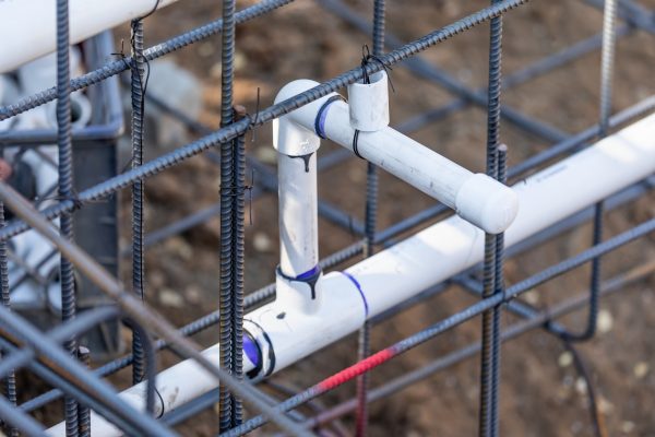 Newly Installed PVC Plumbing Pipes and Steel Rebar Configuration At Construction Site