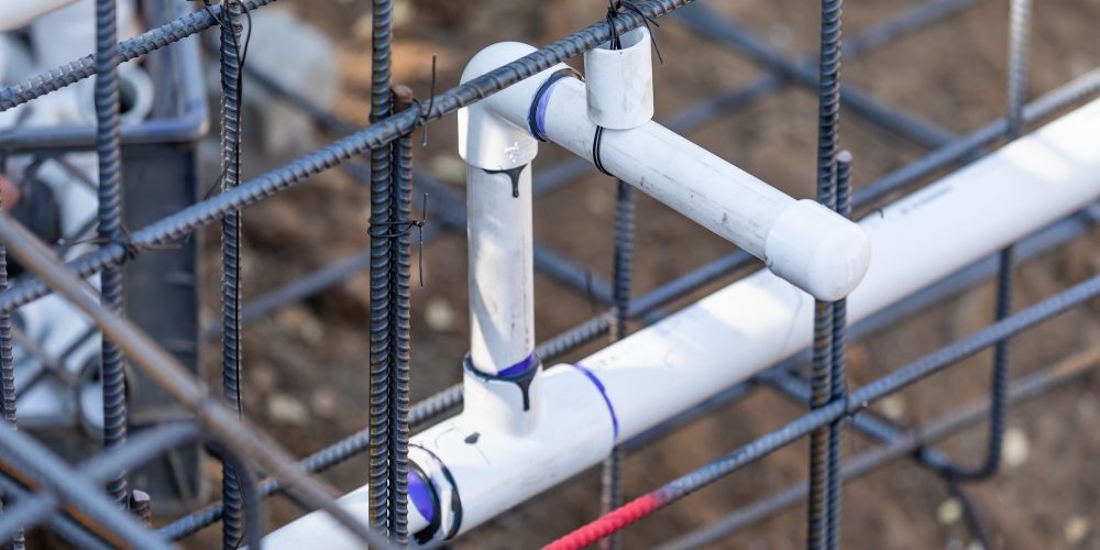 Newly Installed PVC Plumbing Pipes and Steel Rebar Configuration At Construction Site